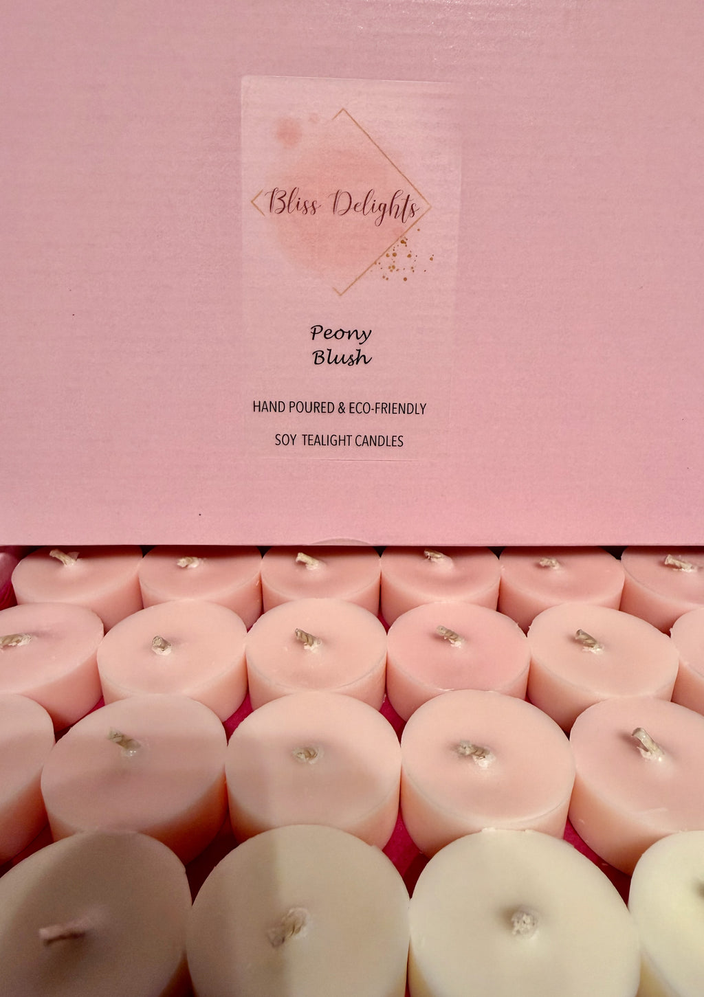 Bliss Delights Peony Blush soy wax tealights in blush pink and ivory, arranged in an open pink box with branded packaging. Hand-poured candles with cotton wicks.
